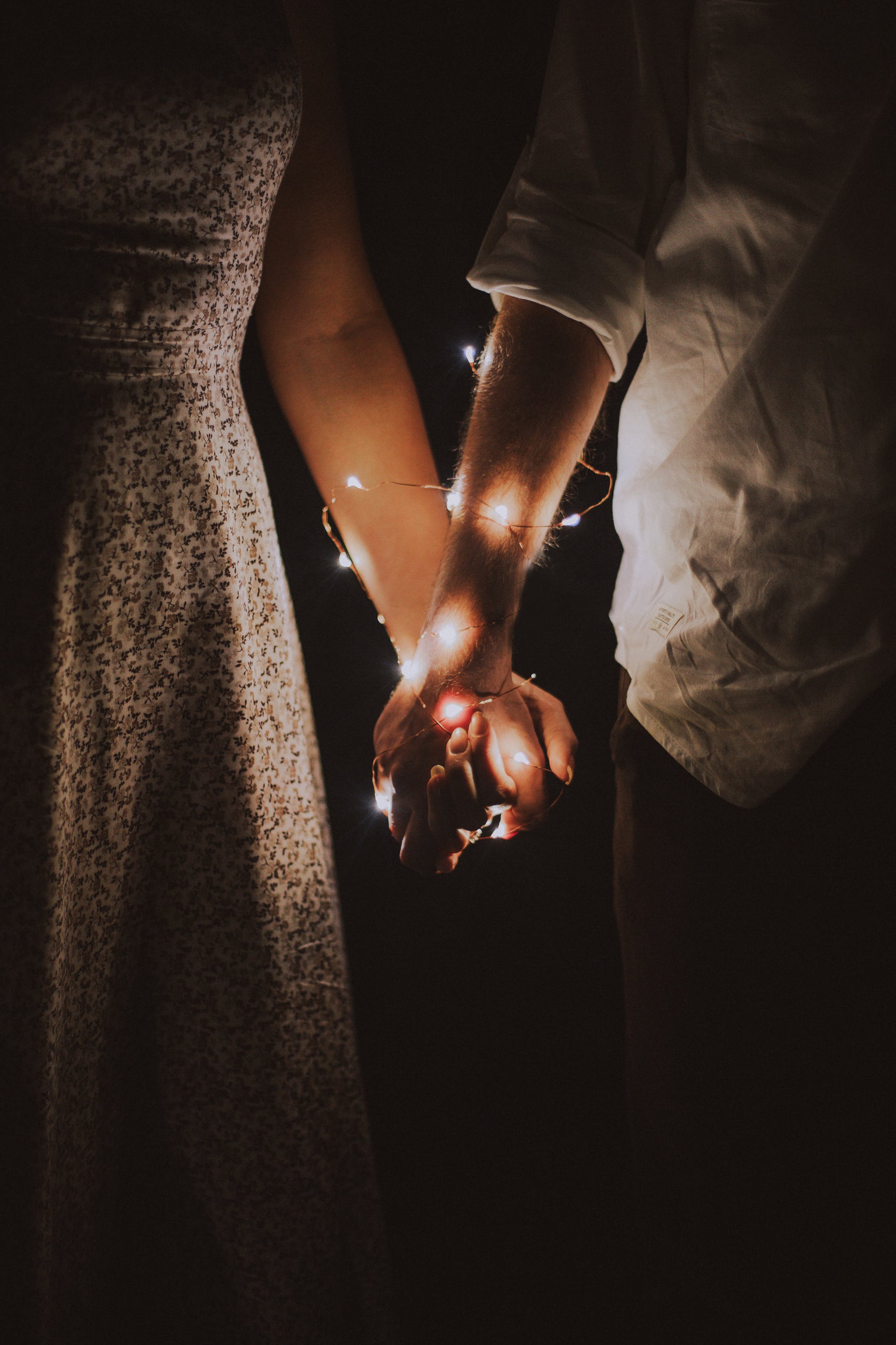 Couple hands wrapped in lights